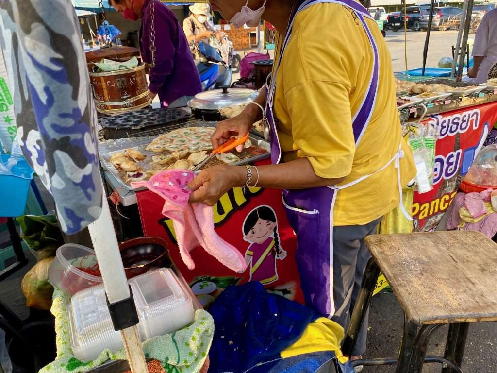 best foods to try in ayutthaya Vendor making crispy Thai pancakes